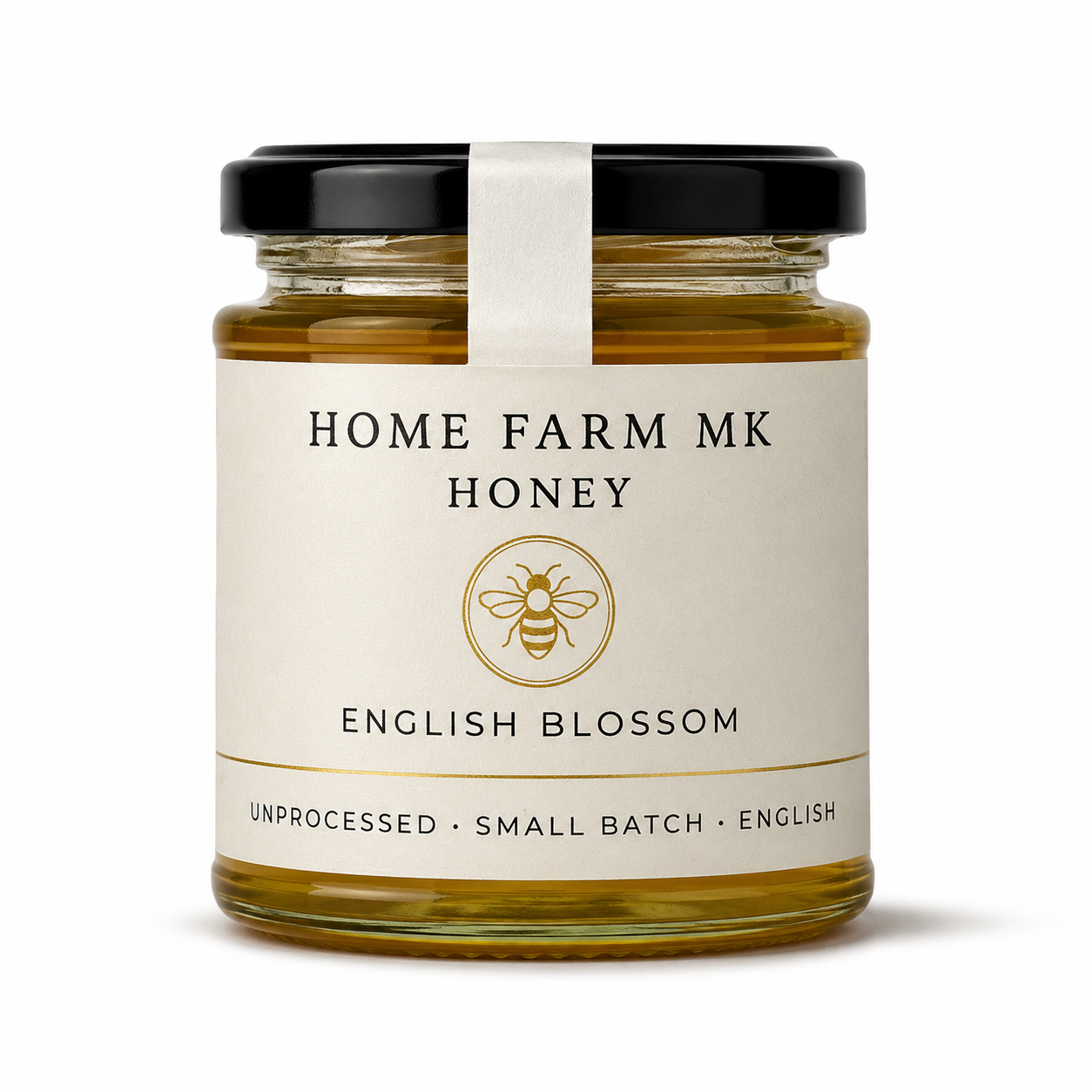 A glass jar of Home Farm Mk English Blossom Honey with a cream-colored label and a black lid, set against a plain white background.