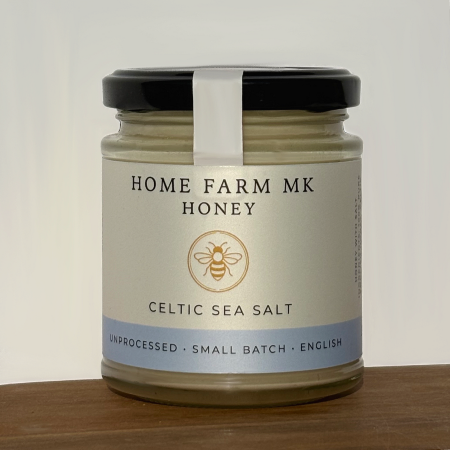 Jar of Home Farm MK Salted Honey with Celtic Sea Salt on a wooden surface