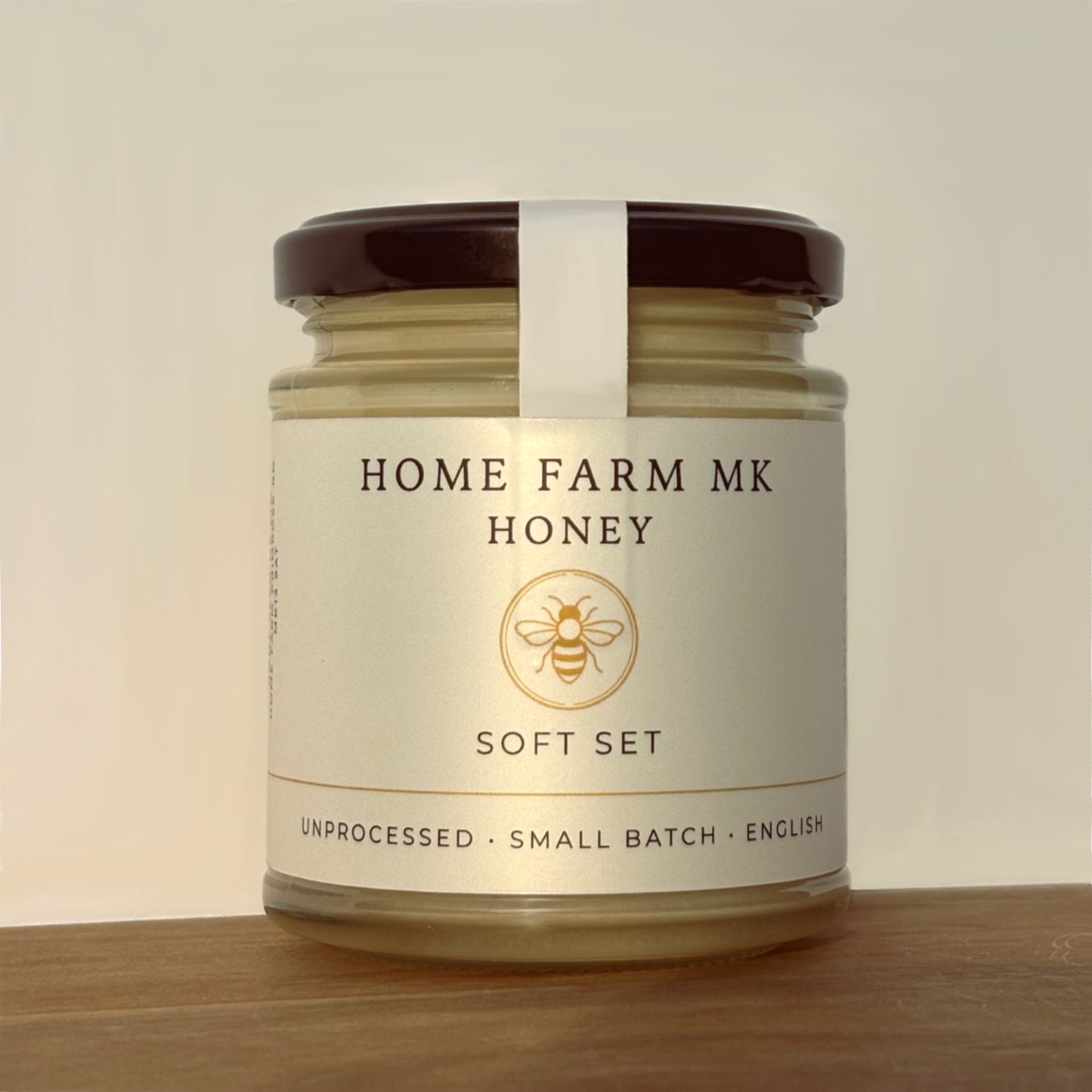Jar of Home Farm MK Soft Set Honey on a wooden surface