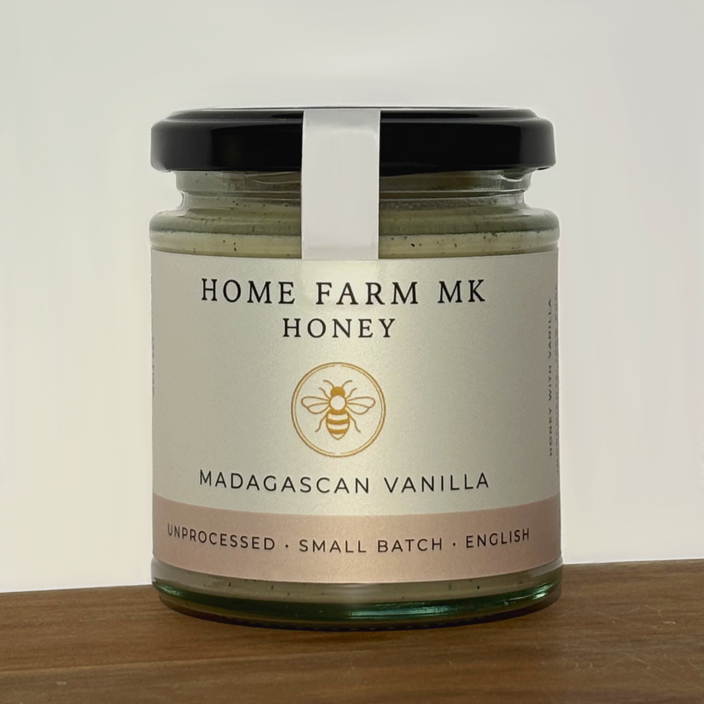 Jar of Home Farm MK Vanilla Honey with Madagascan Vanilla Beans on a wooden surface
