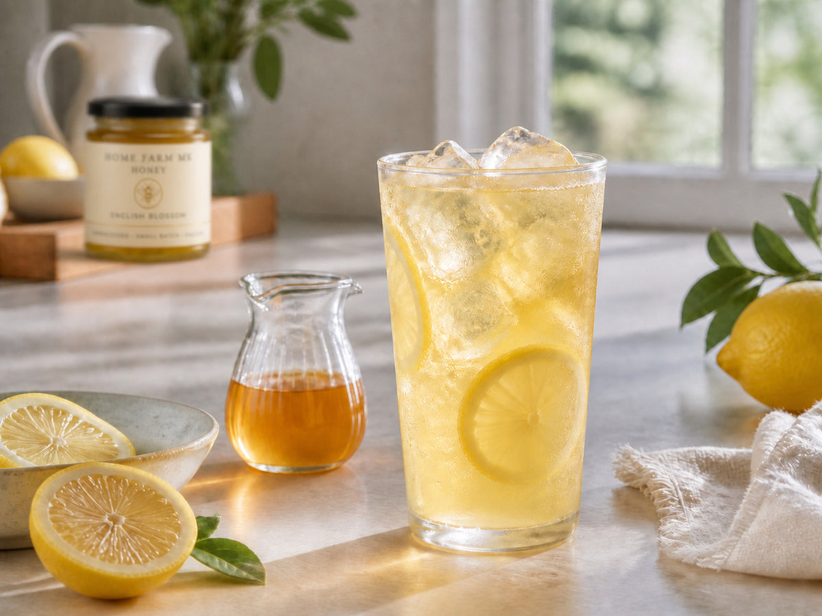 Iced honey lemonade with Pure English Honey softly focused in the background.