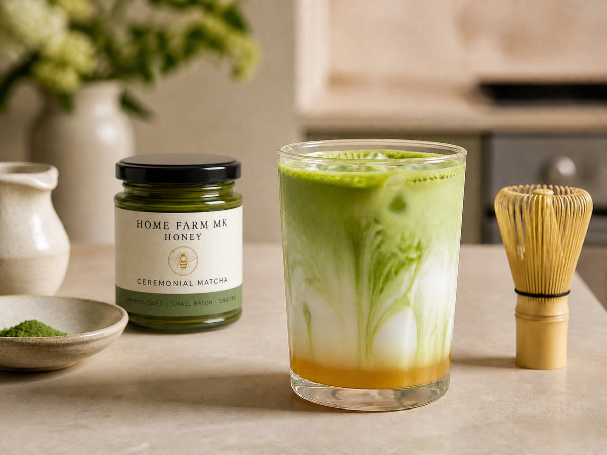 A green matcha honey latte beside Ceremonial Matcha Honey.