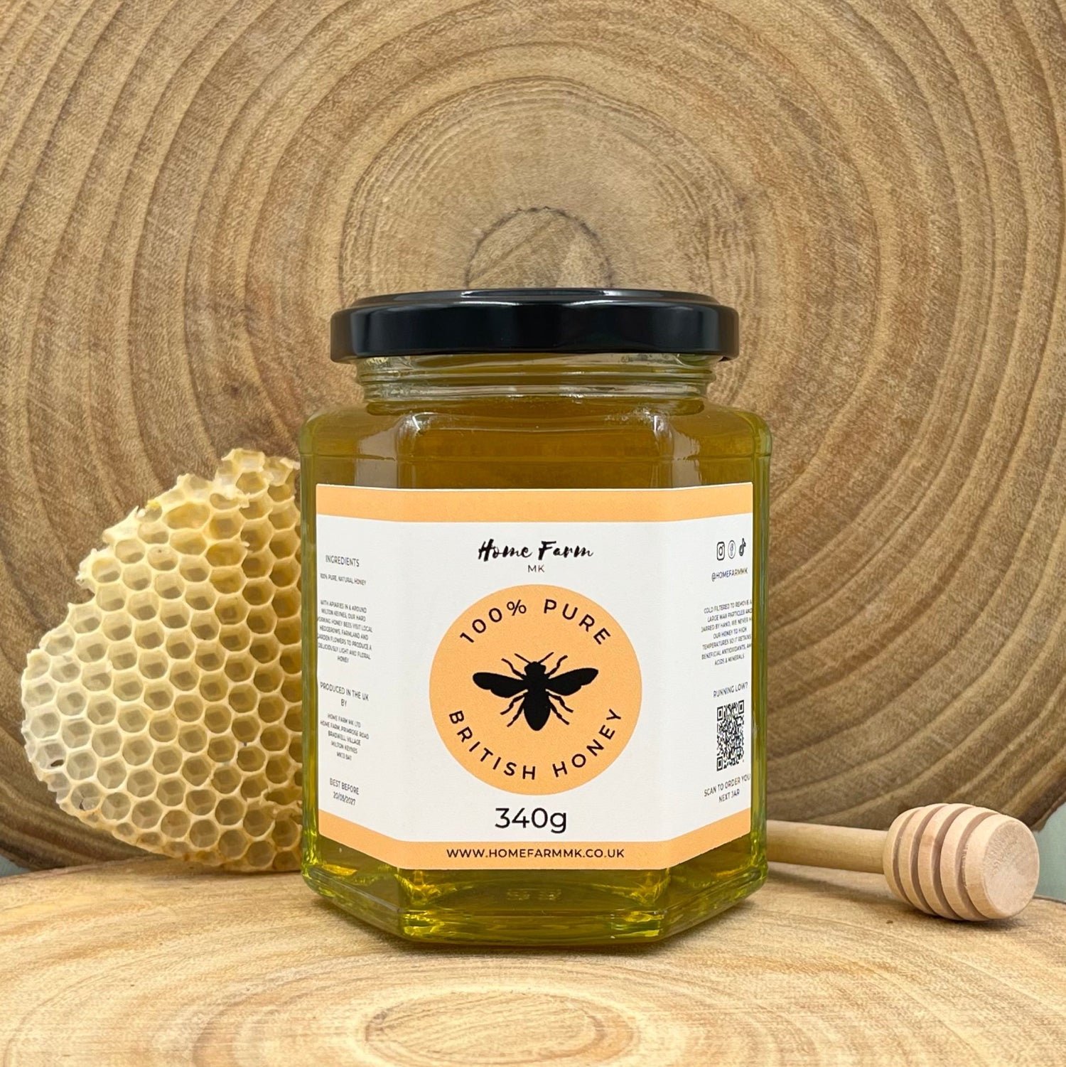 Jar of pure runny honey with a honeycomb and dipper on a wooden background