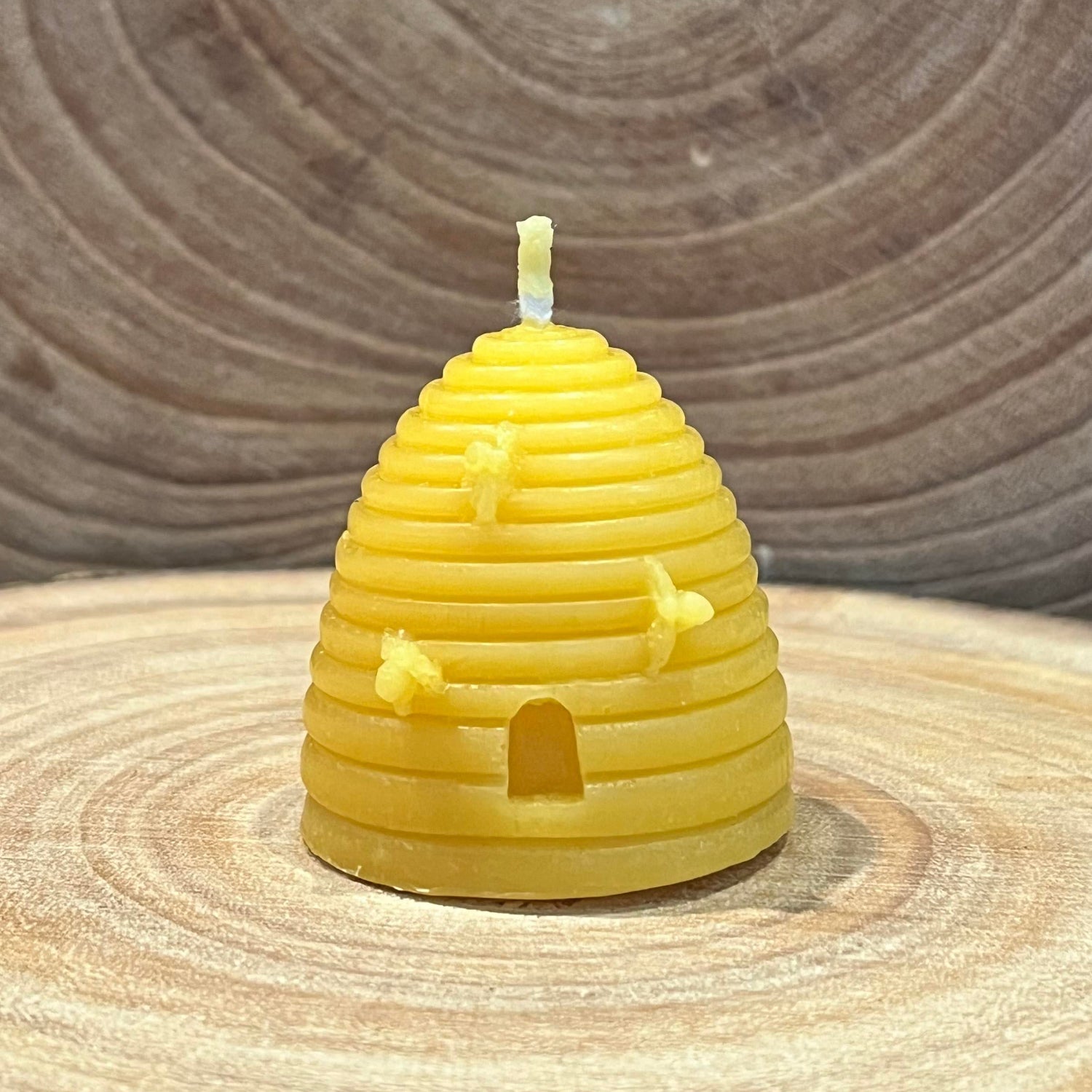 Yellow traditional skep beehive-shaped beeswax candle with small bee details