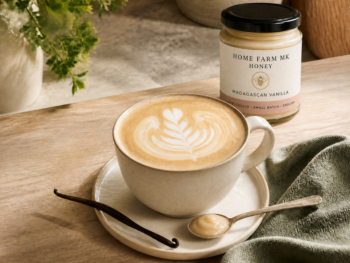 A vanilla honey latte with soft-set honey beside Madagascan Vanilla Honey.